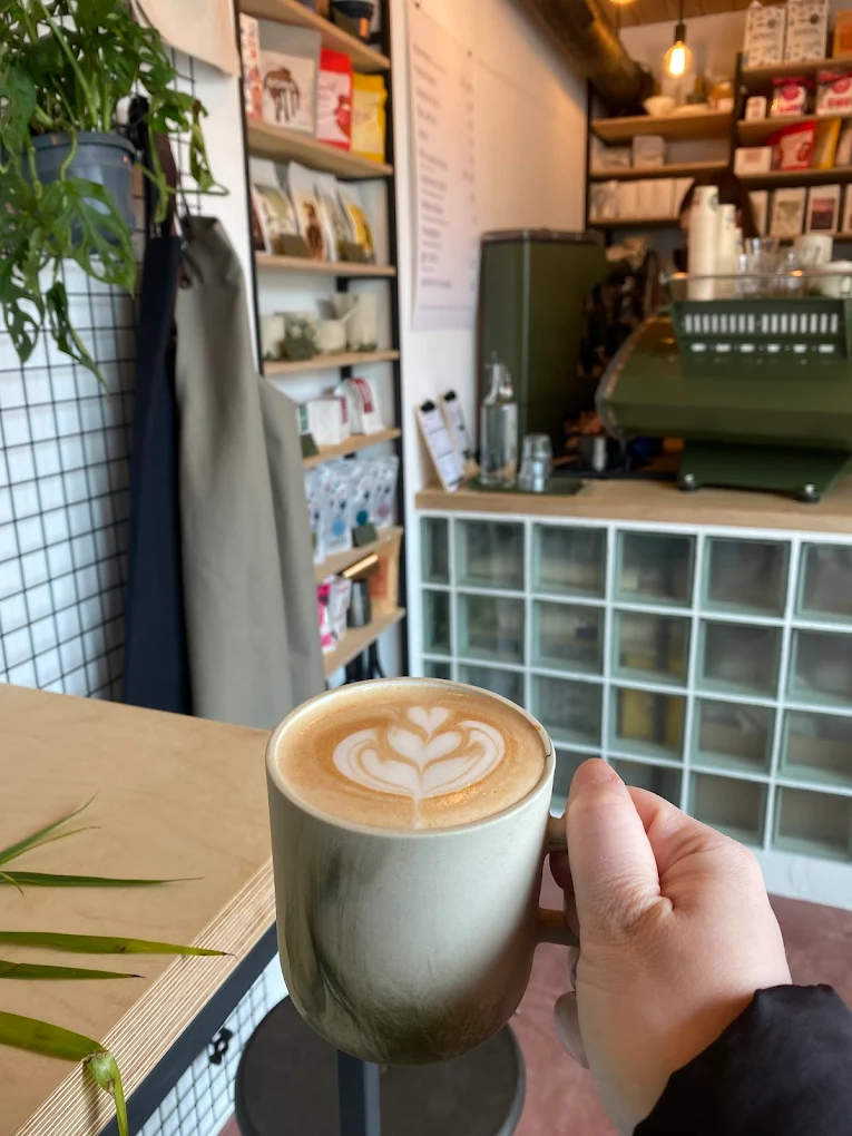 Cappuccino s latte art v hnědém keramickém hrnku